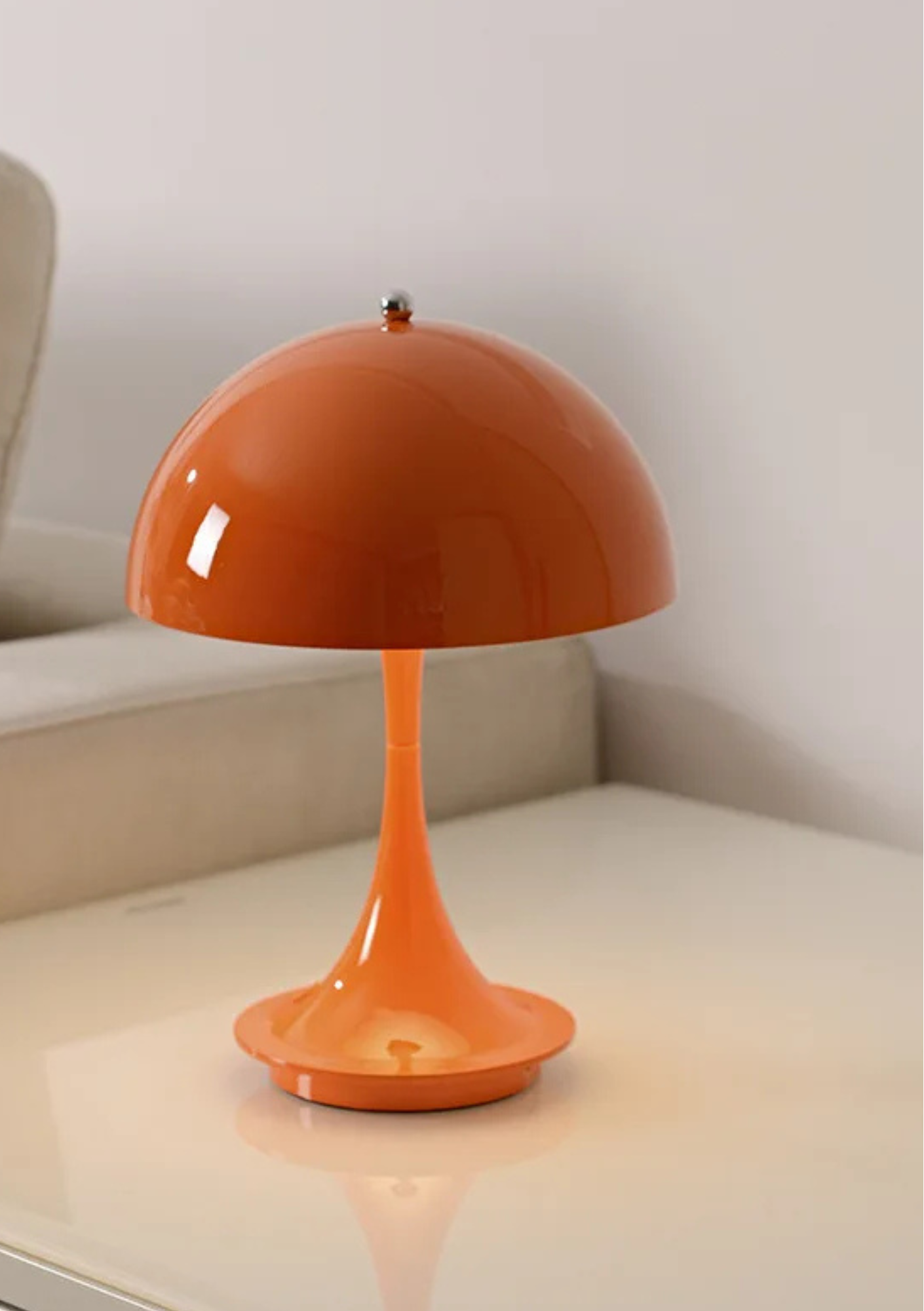 Candeeiro de Mesa laranja sobre a mesa e perto do sofá