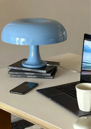 Candeeiro de Mesa azul sobre livros com celular e computador por perto