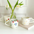 caneca encantadora, feita de porcelana cerâmica, destaca-se pelo design único e romântico da alça em forma de coração, pintada à mão