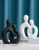 Escultura Decorativa de Casal apoiado em mesa e livro de perto
