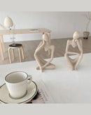 Escultura Decorativa O Pensador em 2 apoiada na mesa com xicara perto