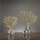 Estatueta Decorativa de Coral Dourado apoiada sobre mesa marrom