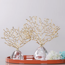 Estatueta Decorativa de Coral Dourado apoiada sobre prateleira