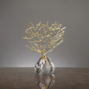Estatueta Decorativa de Coral Dourado apoiada sobre mesa marrom e fundo branco