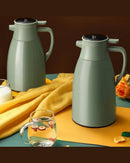 Garrafa Térmica de Café sob mesa com copo perto