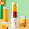 Liquidificador Portátil com laranja e suco de laranla perto