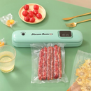 máquina de vácuo verde com linguiça e tomate perto