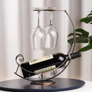 Suporte para vinho e taça sob mesa perto de planta