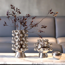 Vaso de Cerâmica Banhado a Prata com planta dentro sob mesa