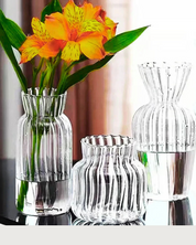 Conjunto de Vasos de Vidro para flores sob mesa com flor amarela dentro